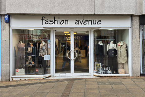 Image showing the exterior of Fashion Avenue in Brentwood. The signage is white with black wording. Mannequins are visible in the window.