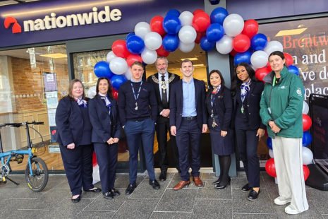 Image taken outside Nationwide in Brentwood, with a red, white and blue balloon arch, featuring staff members including manager Ayesha Sajid, Brentwood Connected BID Manager Sarah Walmsley, and Mayor of Brentwood Cllr Mark Haigh.
