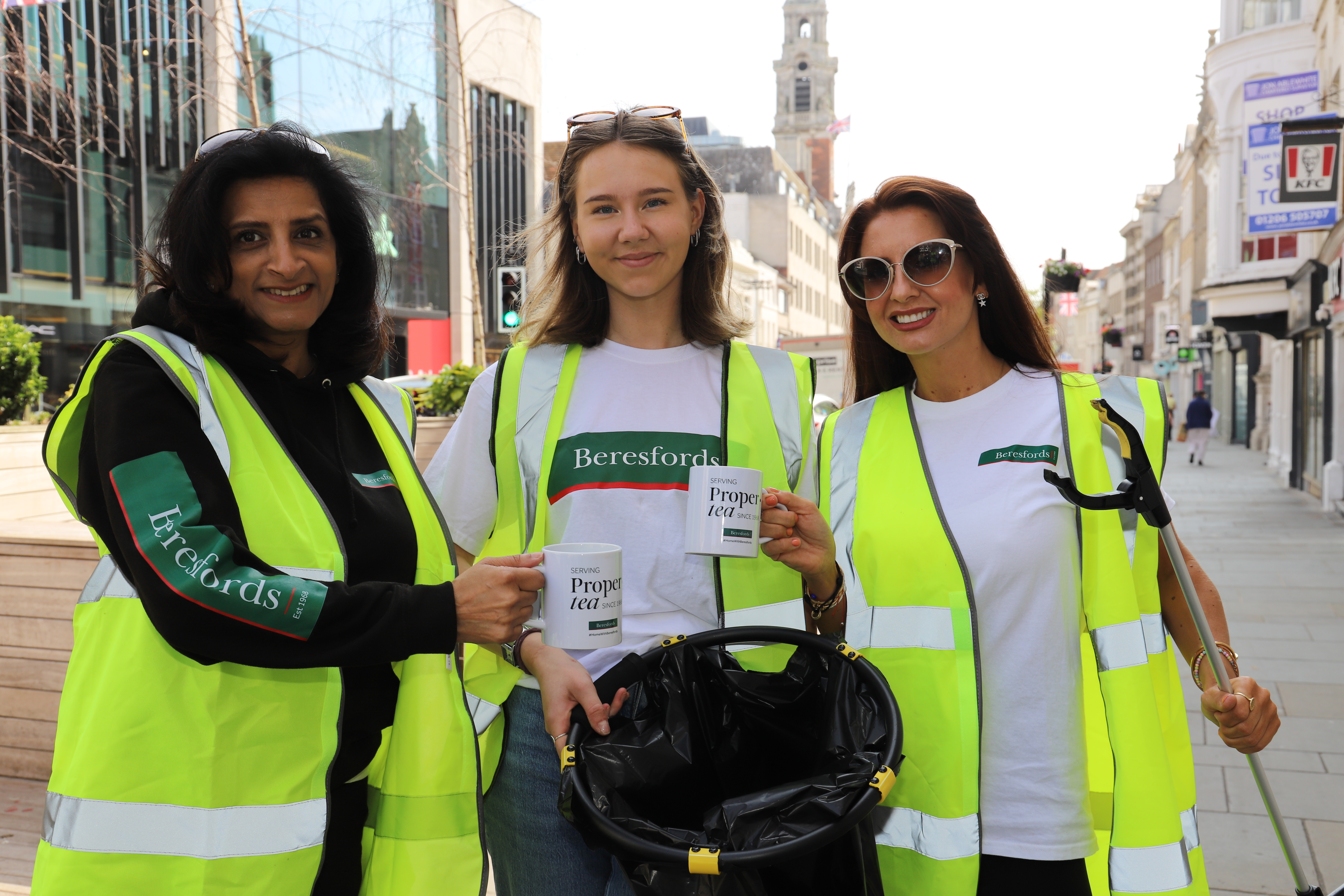 Image showing three Beresfords members of staff on a litter pick, holding Beresfords mugs and wearing branded clothing..