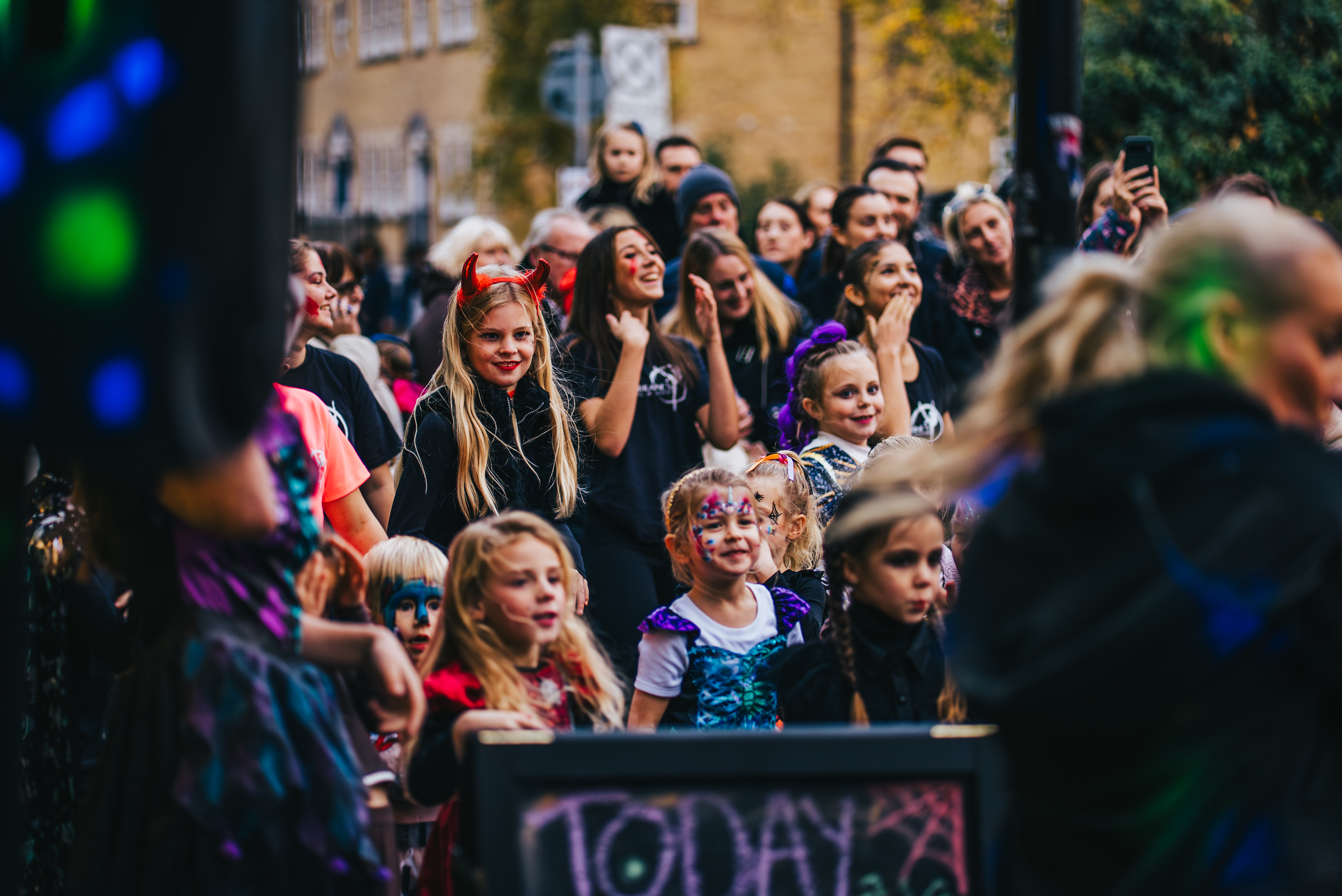 A crowd of people watching a Halloween performance in Crown Street.