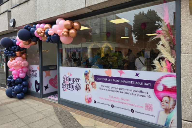 Images showing the exterior of Pamper Me Pretty & Co with pink, black and gold balloons outside and an advertising vinyl in the window.