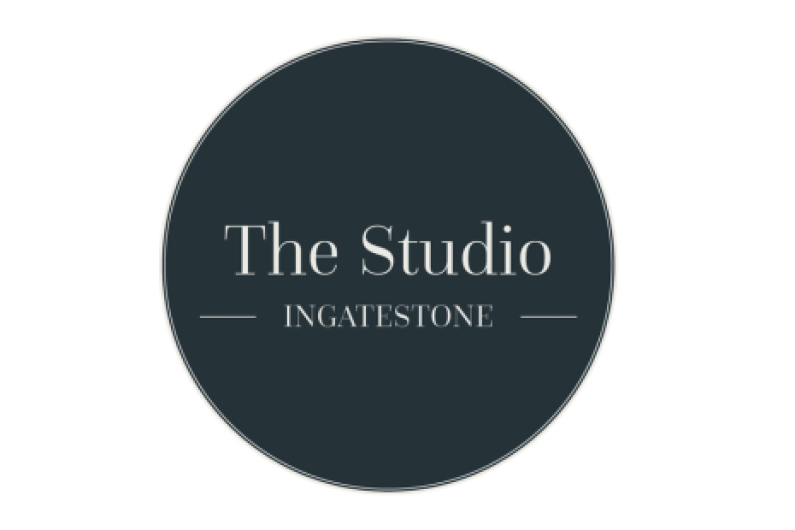 Logo for The Studio Ingatestone, with white text on a dark grey circular background.