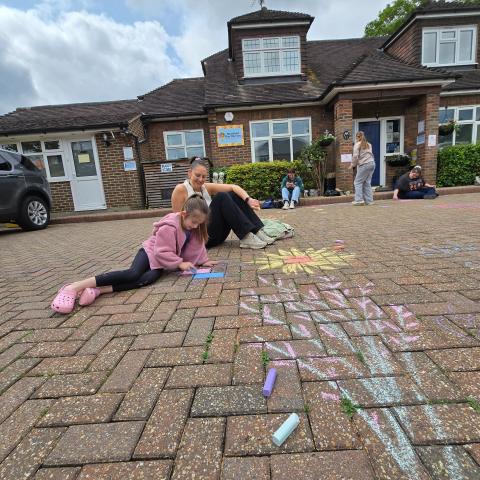 Nicola and child chalk drawing outside Shenfield Day Nursery.