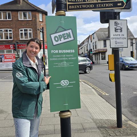 Brentwood Connected BID Manager Sarah Walmsley with an 'Open for Business' sign.